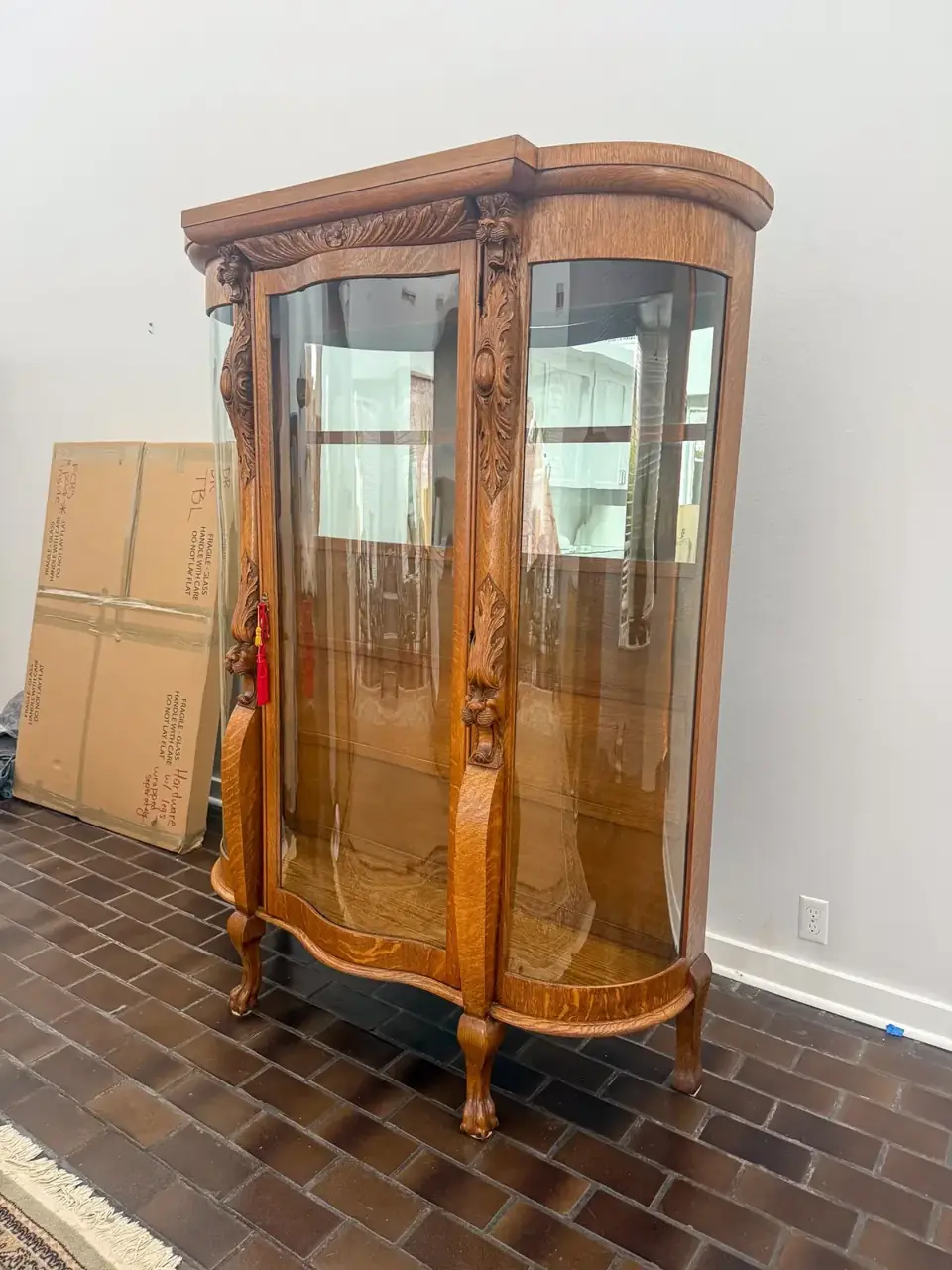 Wooden display cabinet with curved glass panels