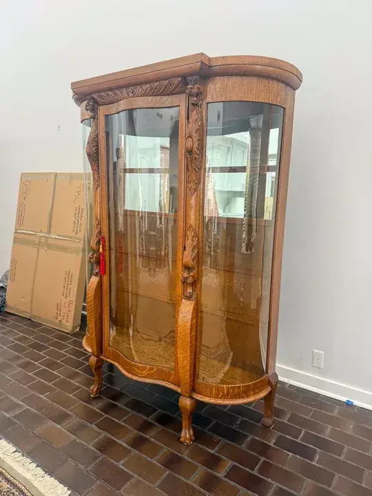 Wooden display cabinet with curved glass panels
