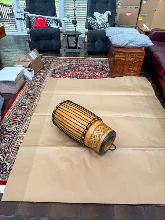 Cylindrical clock component resting on packing paper