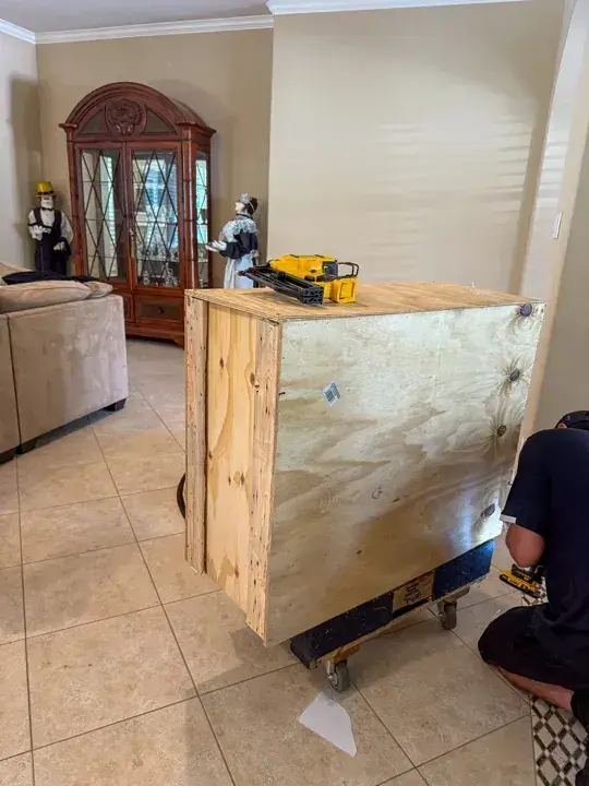 Plywood moving crate on a padded dolly during assembly
