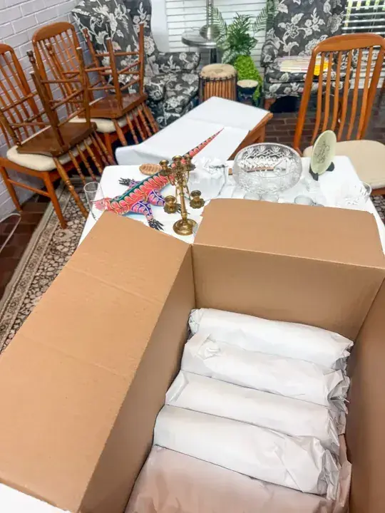 Individually wrapped pieces packed in a carton beside a dining table