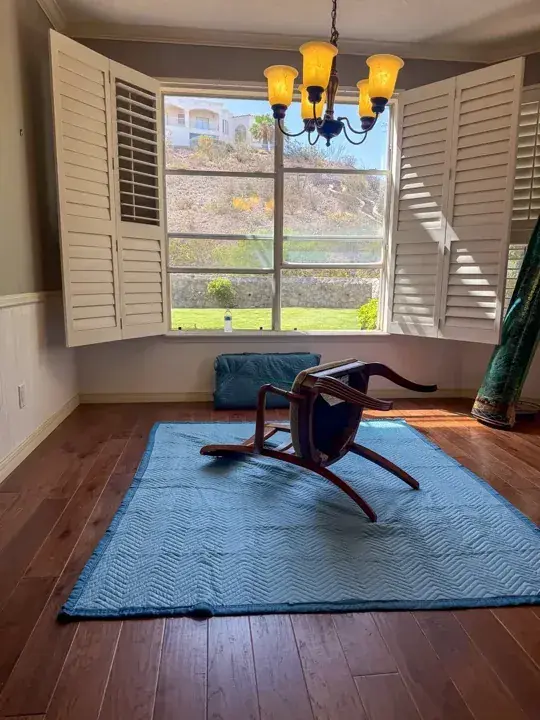 Wooden chair laid on a moving blanket during preparation