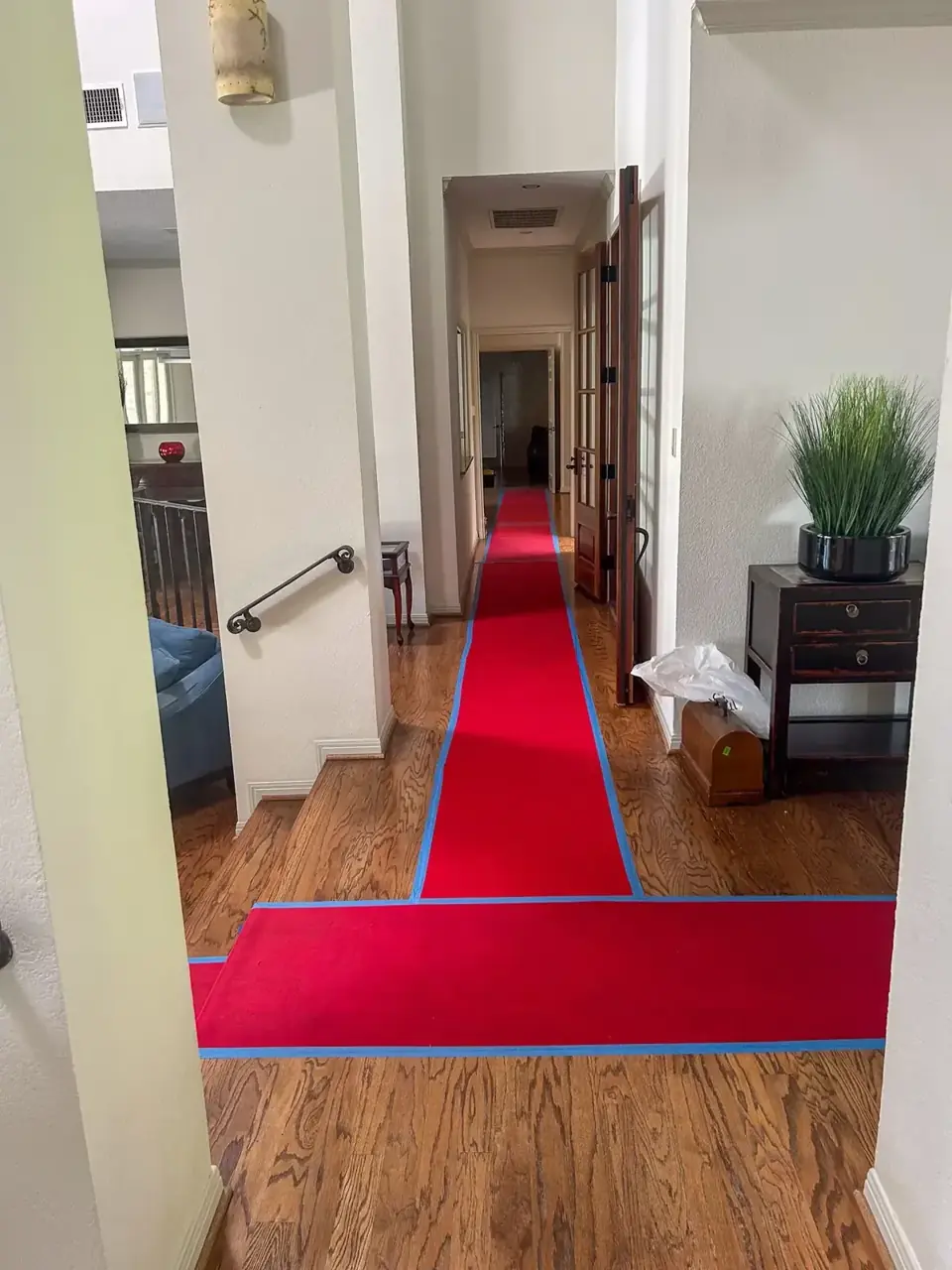 Red floor runners protecting a hallway and turning into a room