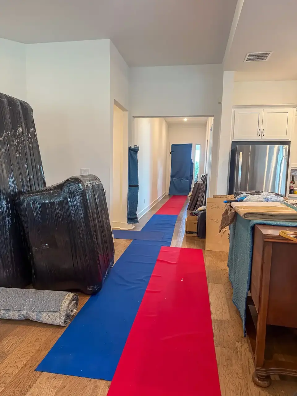 Red and blue floor runners through a home with protected furniture