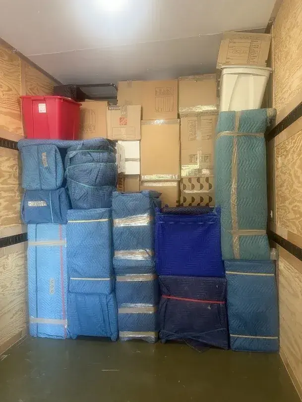 Cartons and padded furniture arranged inside a moving truck