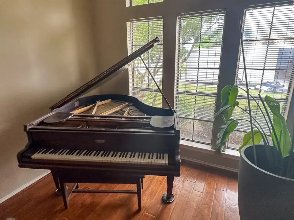 Baby grand piano handled by First Class