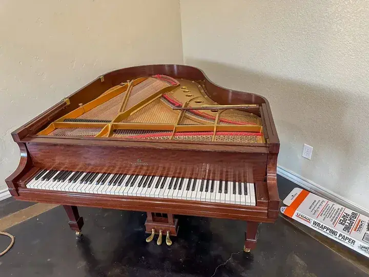 Wood finish Kurtzmann baby grand piano with its lid removed