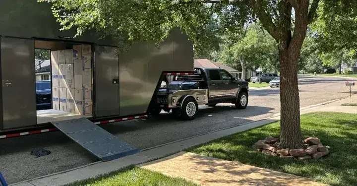 Moving truck and enclosed trailer outside a home