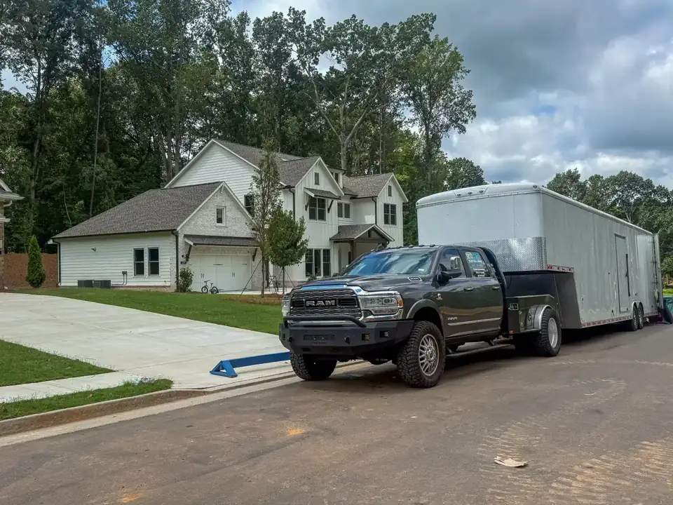 Pickup and enclosed moving trailer parked outside a home