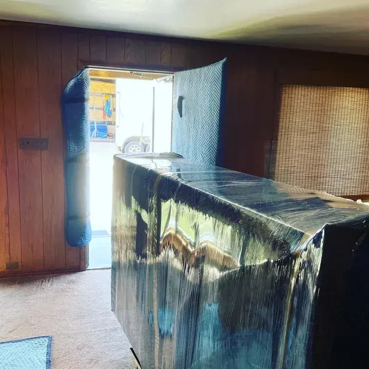 Large cabinet protected with pads and stretch wrap
